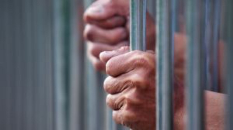 Prisoner Holding Bars In Prison